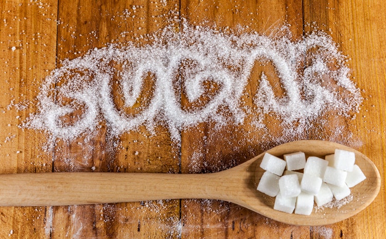 The word sugar written into a pile of sugar