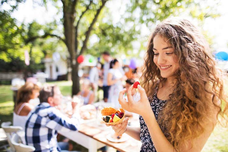 woman eating fruit at an outdoor party