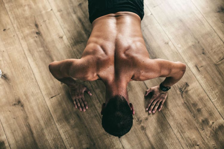 View of a person's muscular back as he does pushups