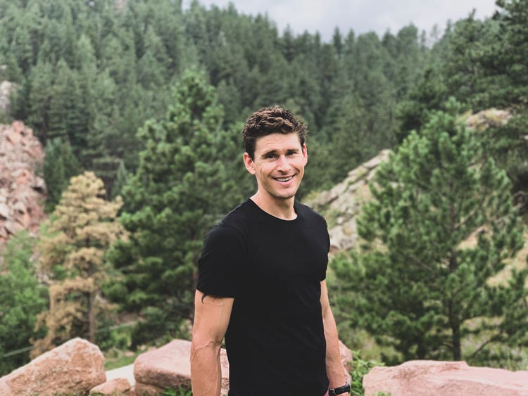 Ben Greenfield smiling in a forest.
