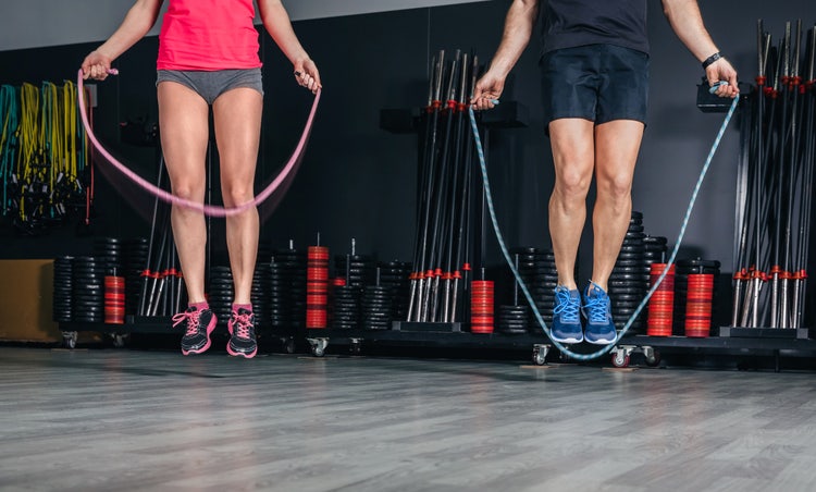 People legs doing exercises with jumping ropes