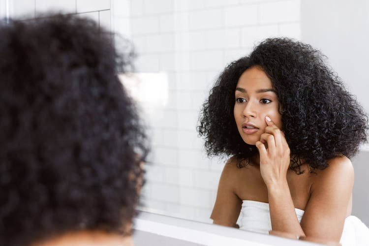 person-examining-skin-in-mirror