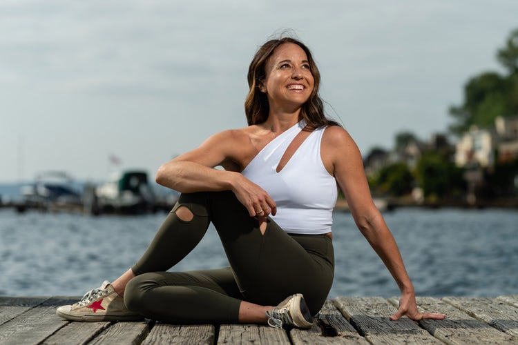 Tiffany Cruikshank in a seated yoga twist on a boat dock
